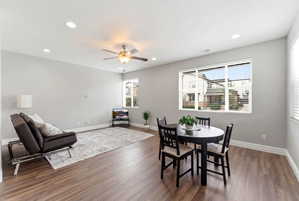 Open-concept living and dining area featuring wood-finish flooring, recessed lighting, and a ceiling fan