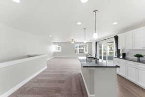 Modern kitchen featuring white cabinetry, subway tile backsplash, and dark countertops
