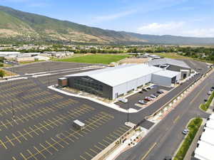 Modern commercial building featuring extensive paved parking, a large lot, and a prominent facade with multiple windows