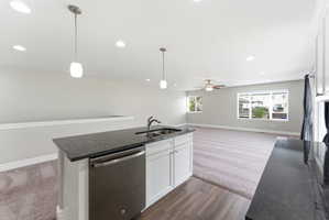 Kitchen island featuring a stainless steel dishwasher and undermount sink