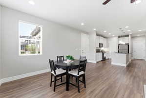 Open-concept living space featuring wood-finish flooring, recessed lighting, and a modern kitchen