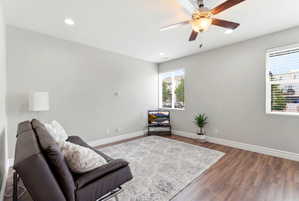 Spacious room featuring wood-finish flooring, light grey walls, and white baseboards