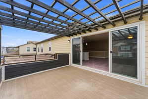 Outdoor deck featuring a dark wood pergola and composite decking