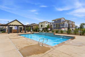Outdoor swimming pool with integrated waterfall features and a surrounding concrete deck
