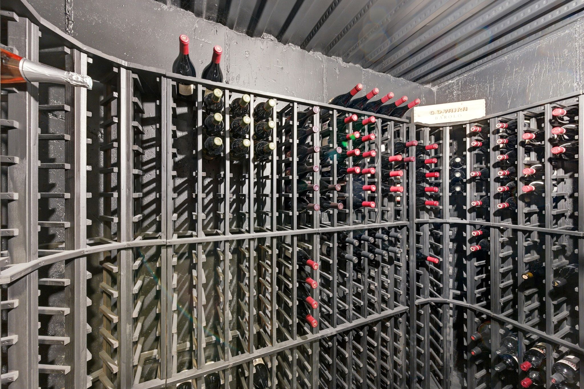 Dedicated wine cellar featuring extensive metal racking, curved shelving, and capacity for numerous bottles