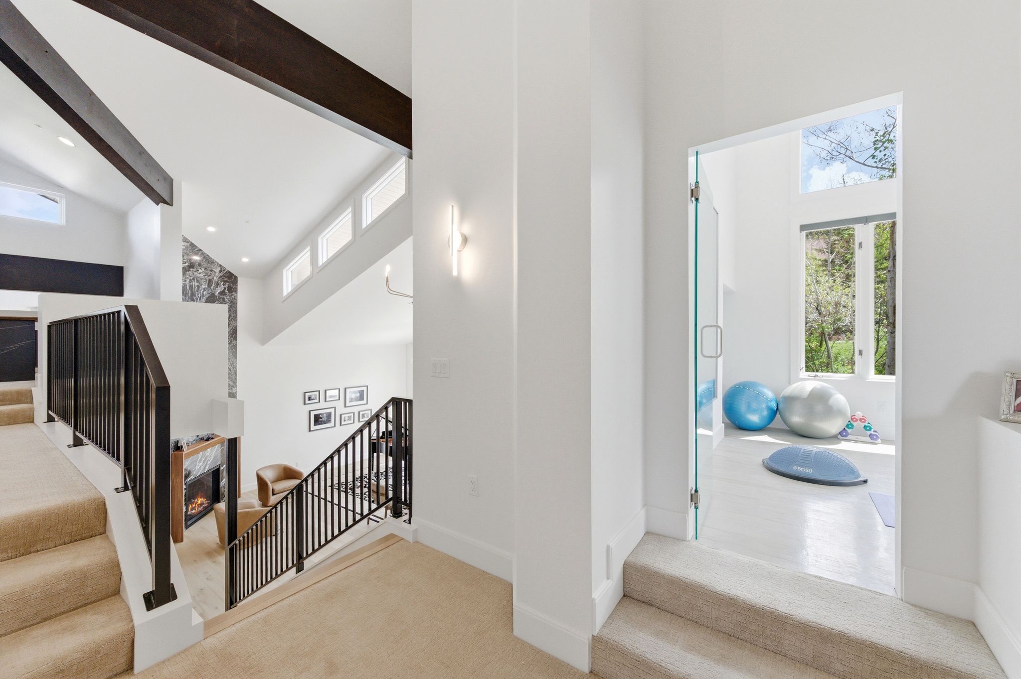 Upper level landing featuring carpeted stairs and a glass entry door