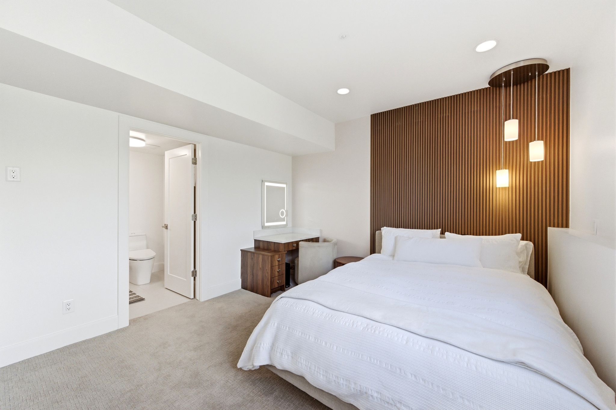 Bedroom with a modern wood-slat accent wall, recessed lighting, and a triple pendant light fixture