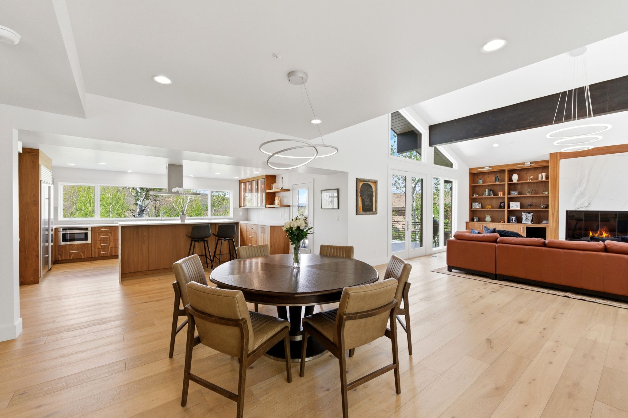 Open-concept living space featuring wood-finish flooring, recessed lighting, and a vaulted ceiling with exposed beams