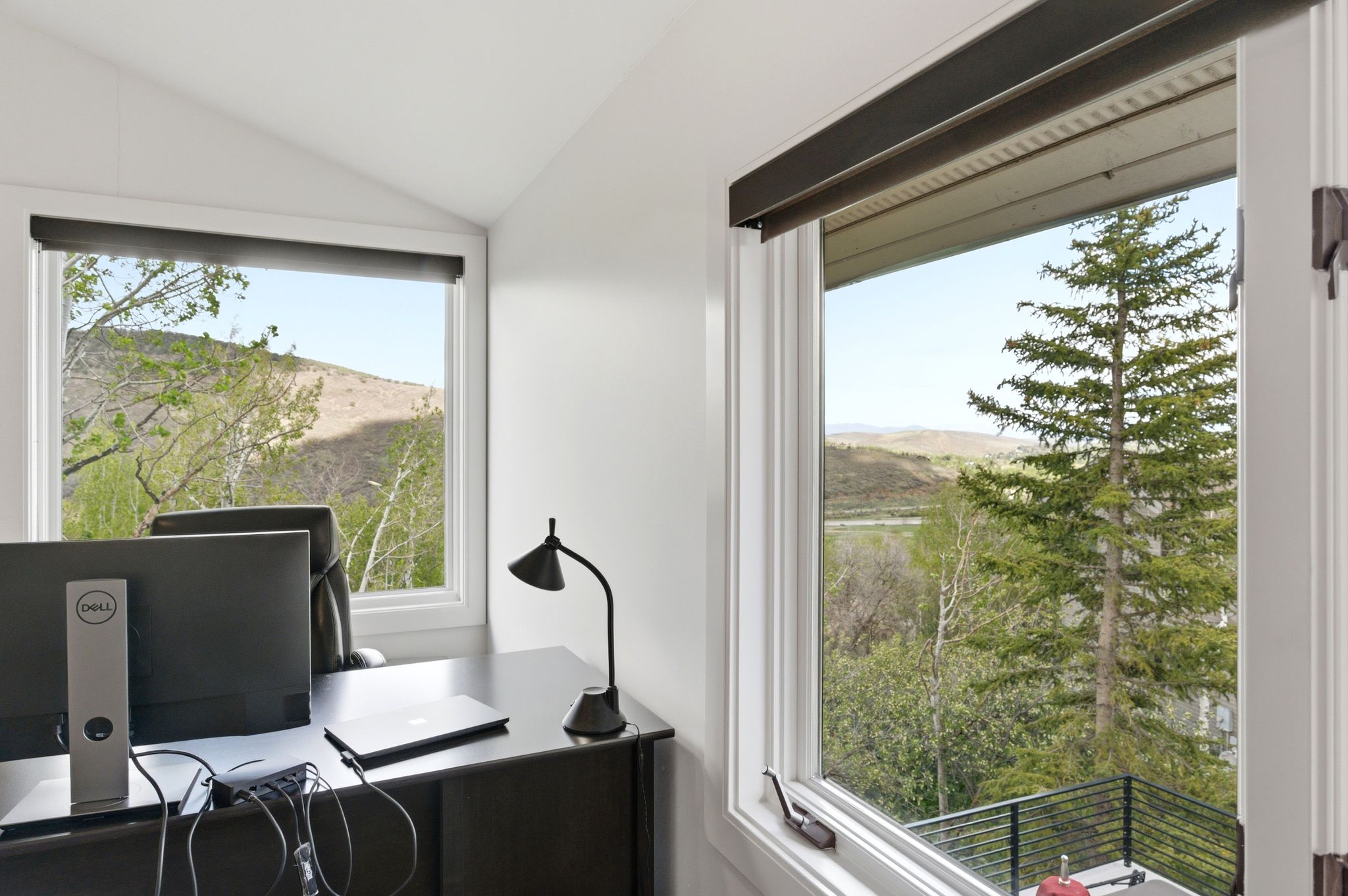 Bright interior space featuring multiple windows with natural light and expansive mountain scenery