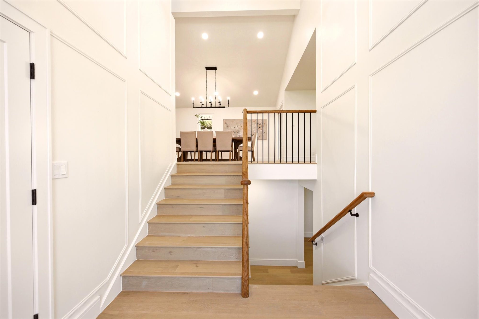 Light wood-finish staircase with wood handrails and black metal balusters