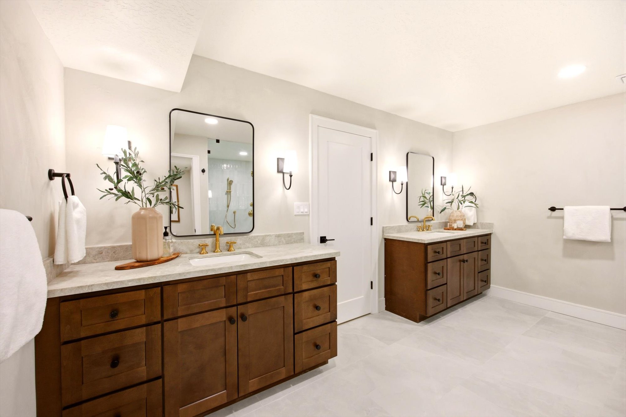 Dual vanity bathroom featuring light-colored walls and flooring