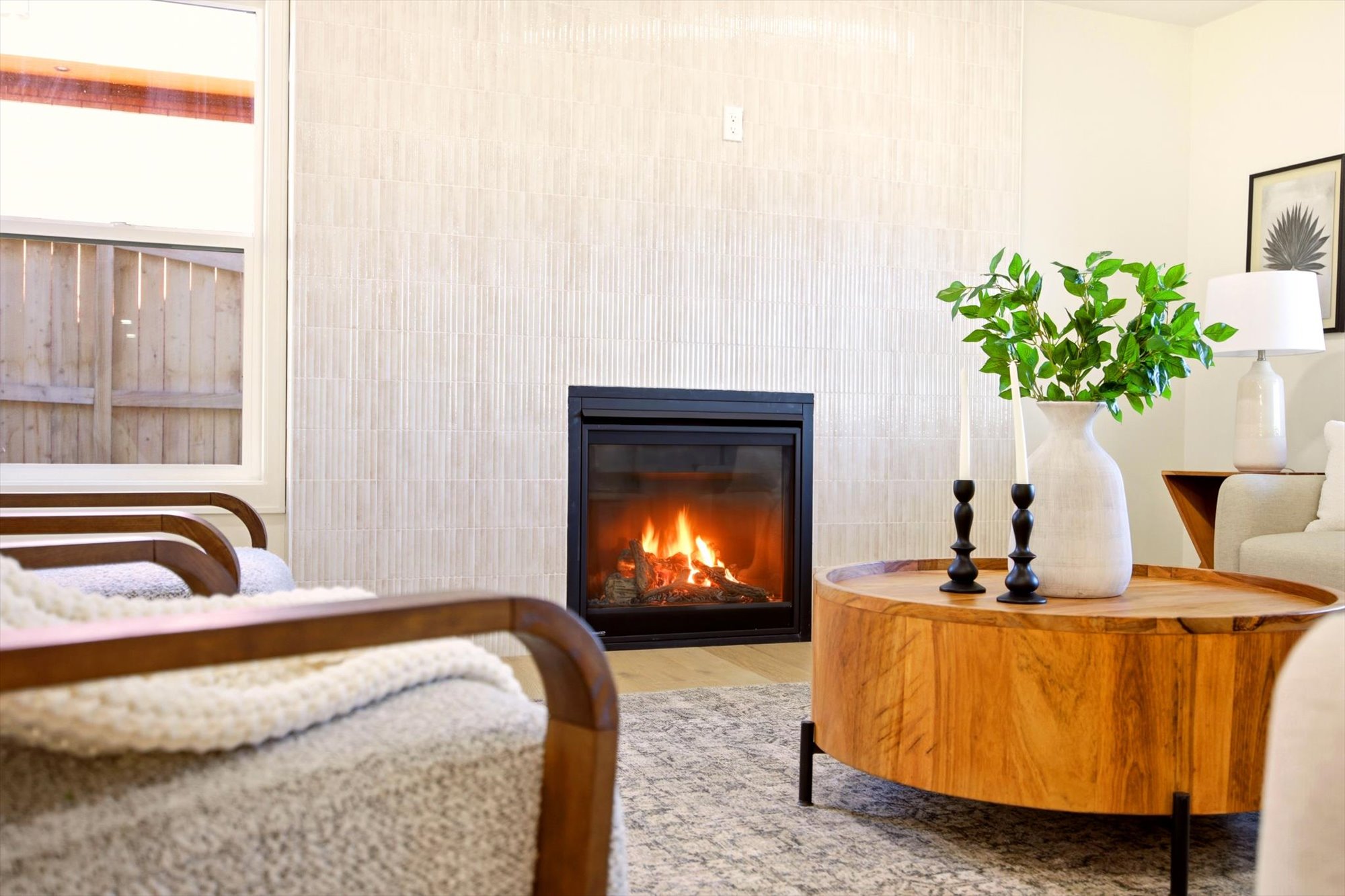 Modern fireplace with a black glass front, set into a textured vertical tile wall