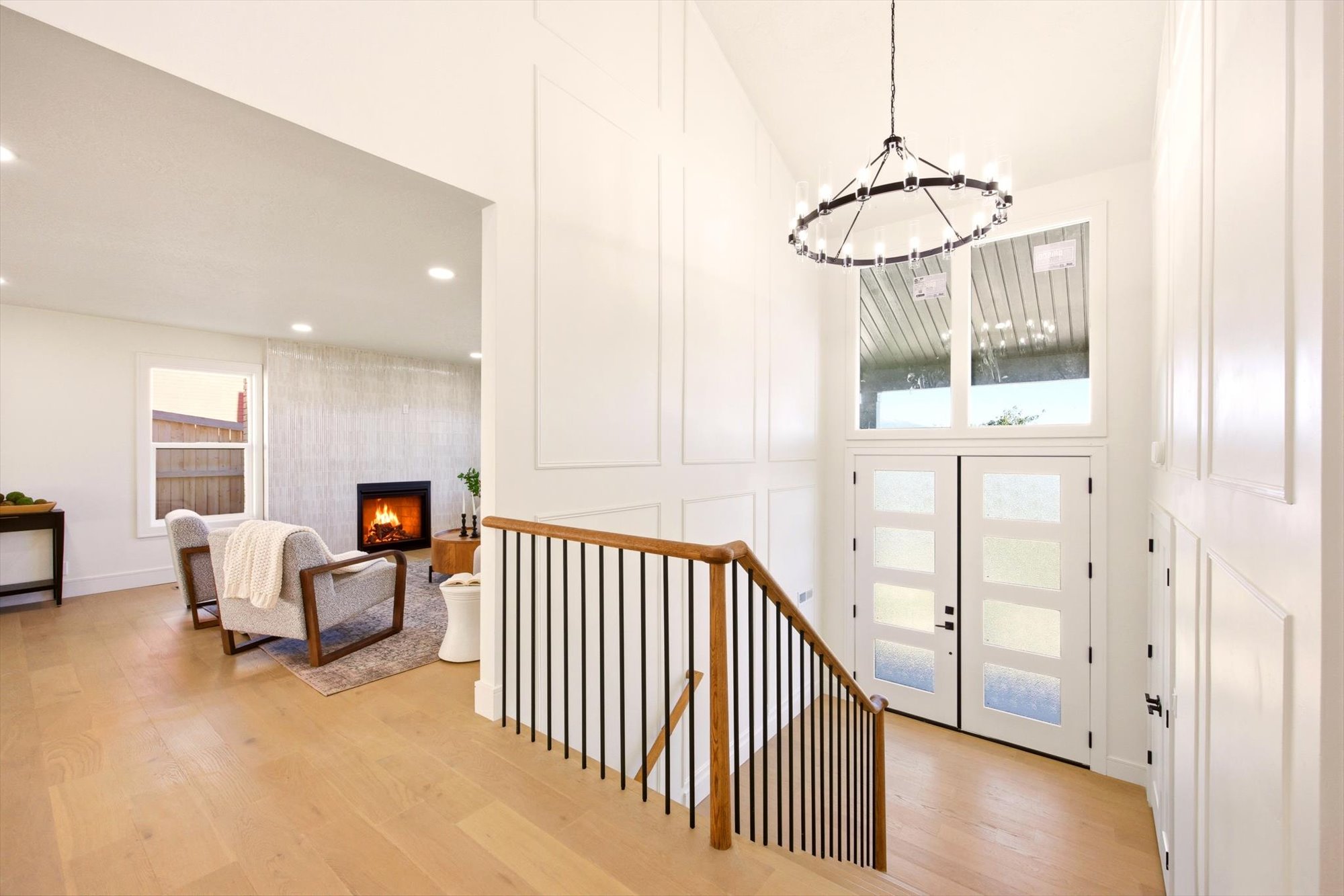 Grand entryway featuring a soaring ceiling, decorative wainscoting, and a contemporary chandelier