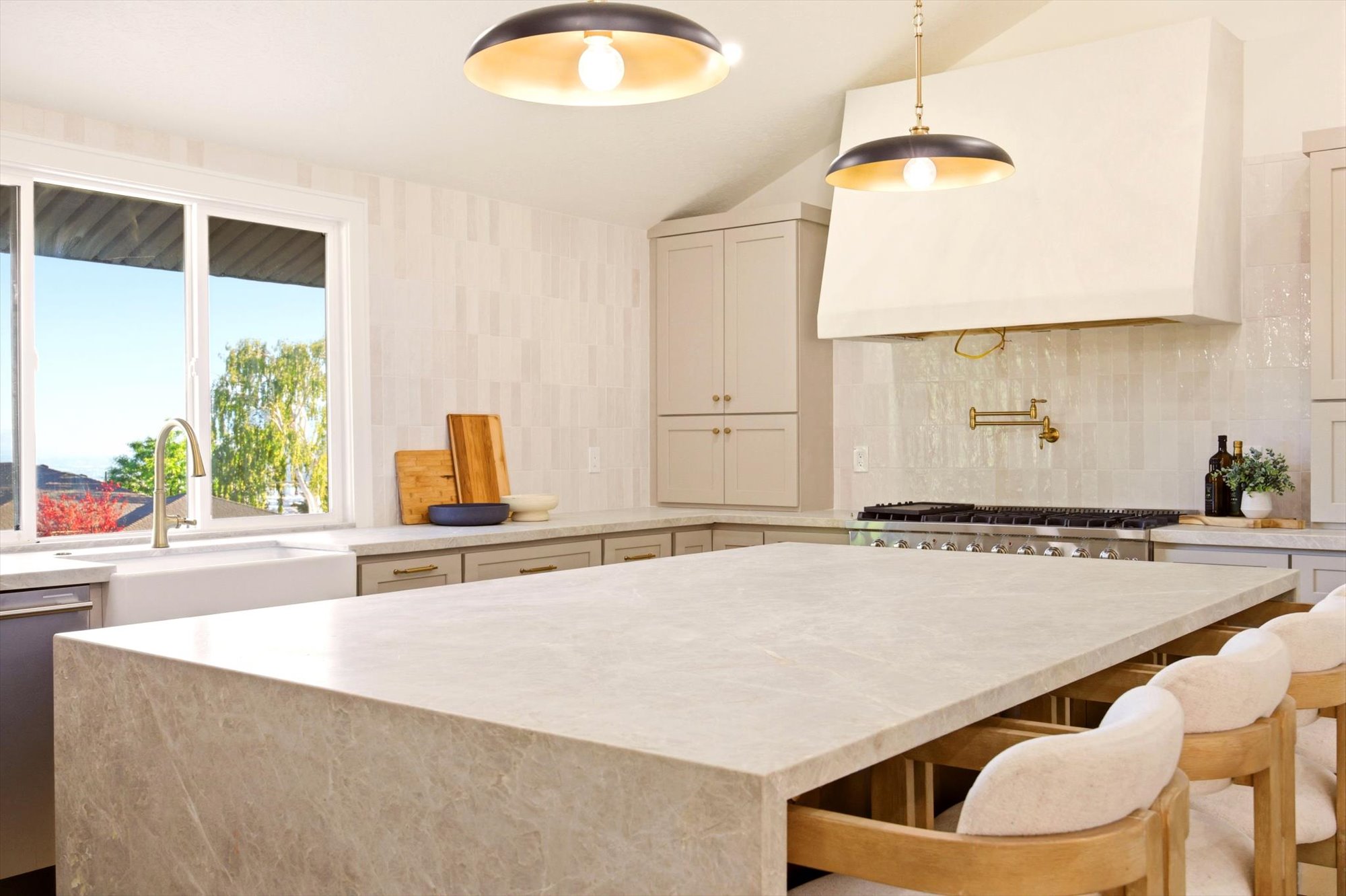 Expansive kitchen island featuring a waterfall edge and seating for four