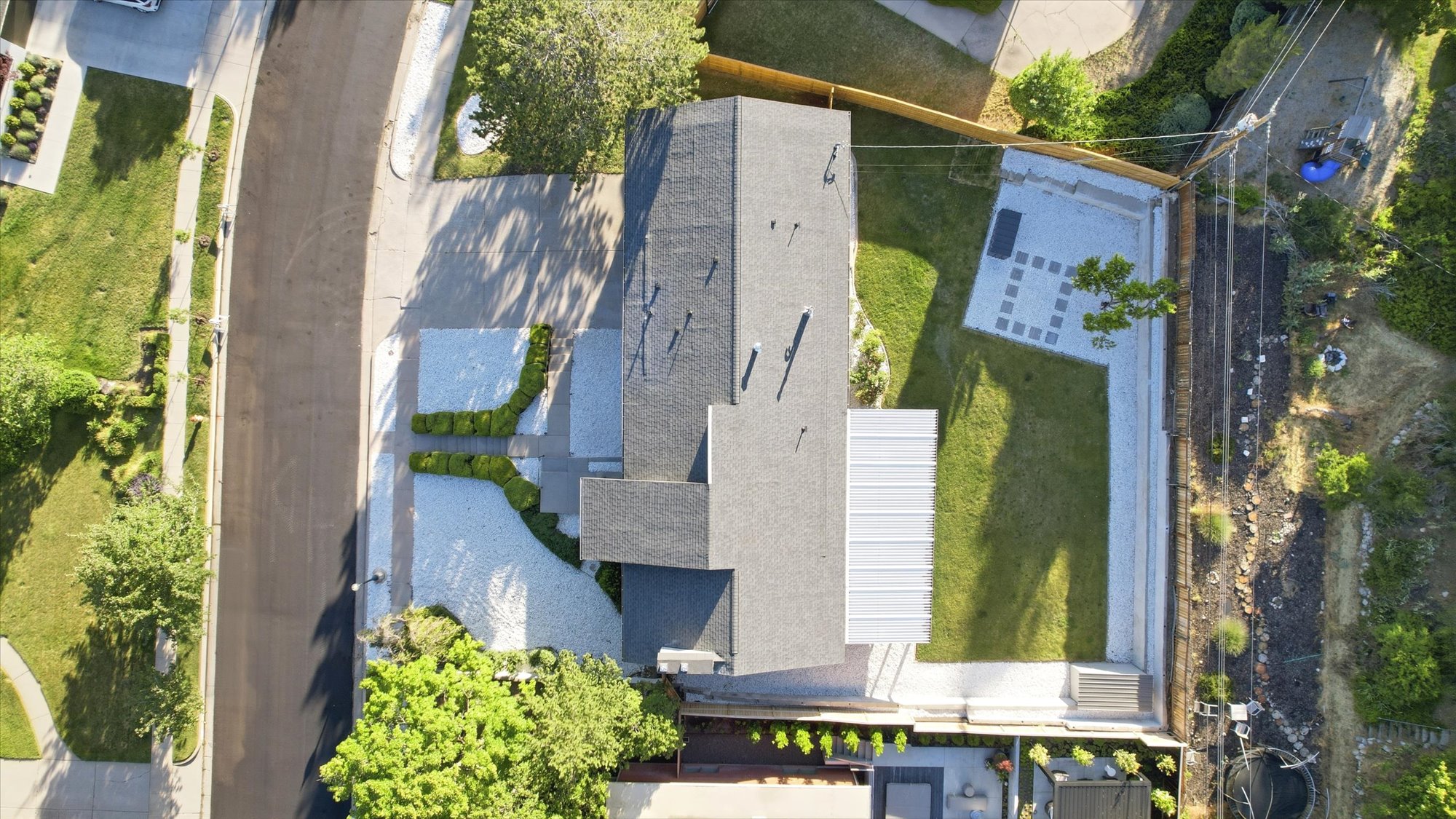 Expansive property featuring a grey shingle roof and a flat white roof section