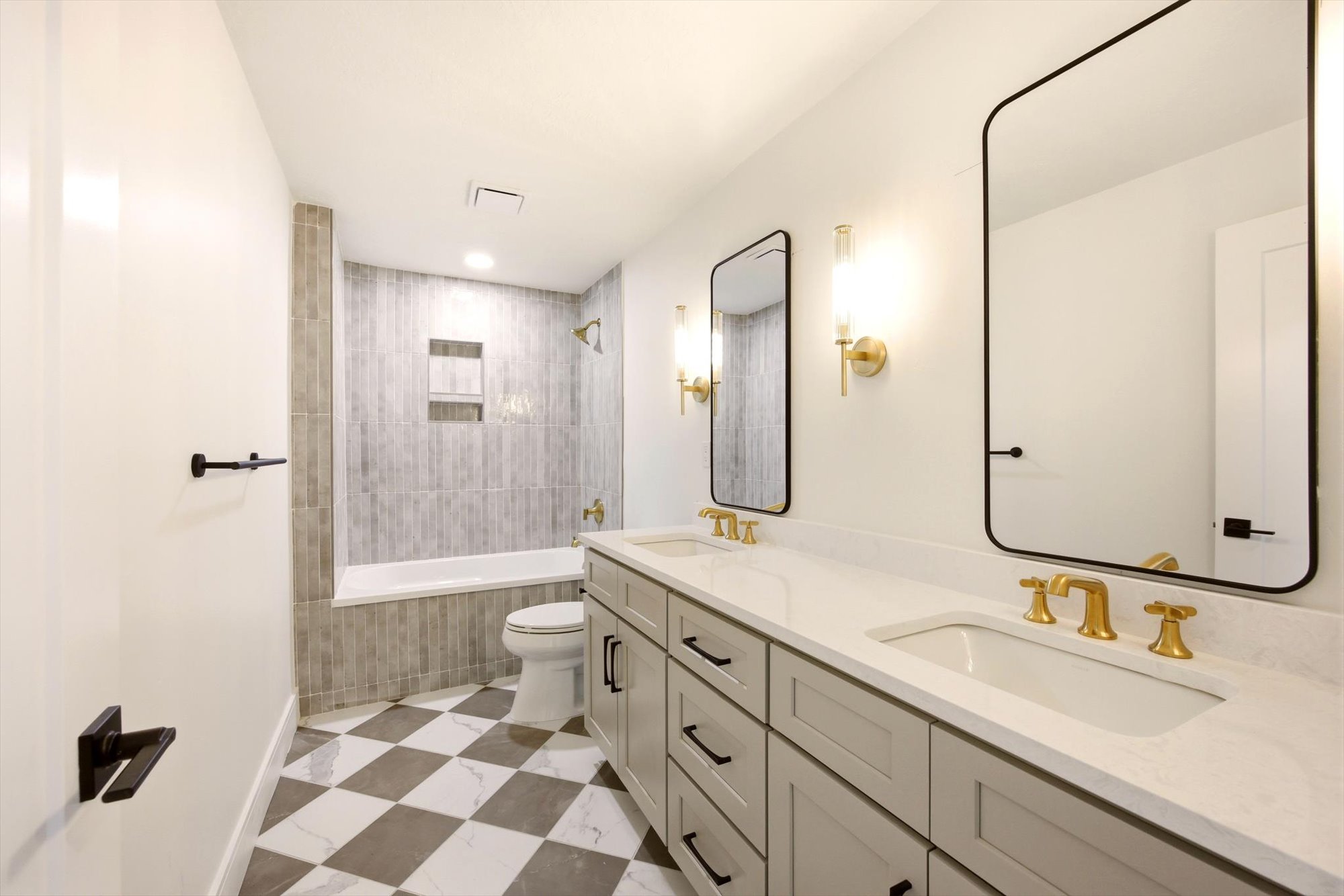 Dual vanity with white countertops and gold-finish fixtures