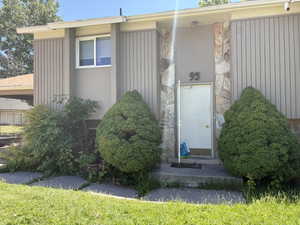 Property entrance featuring a stone facade accent, vertical siding, and a single window