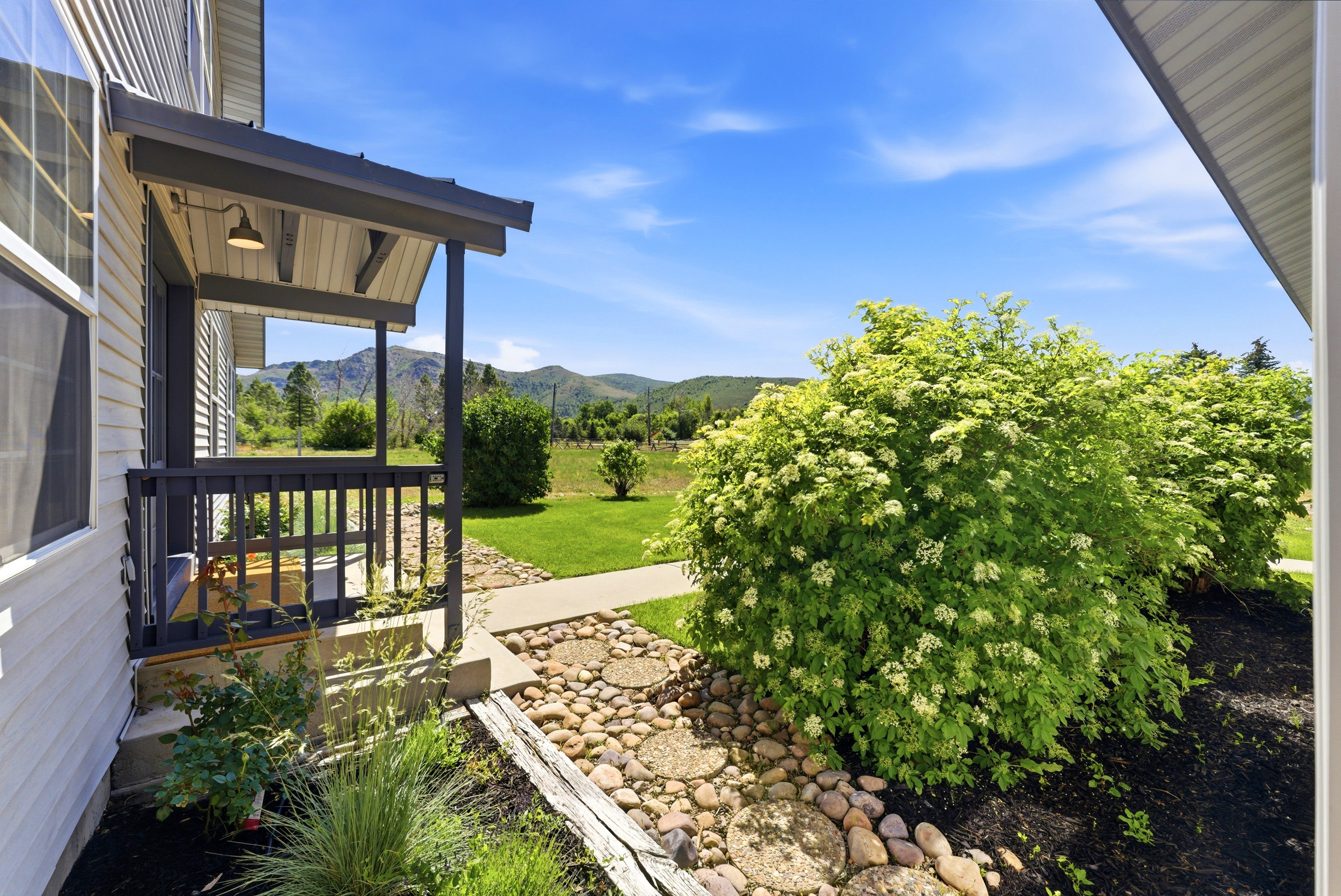 Front porch with dark gray railing and overhead lighting fixture