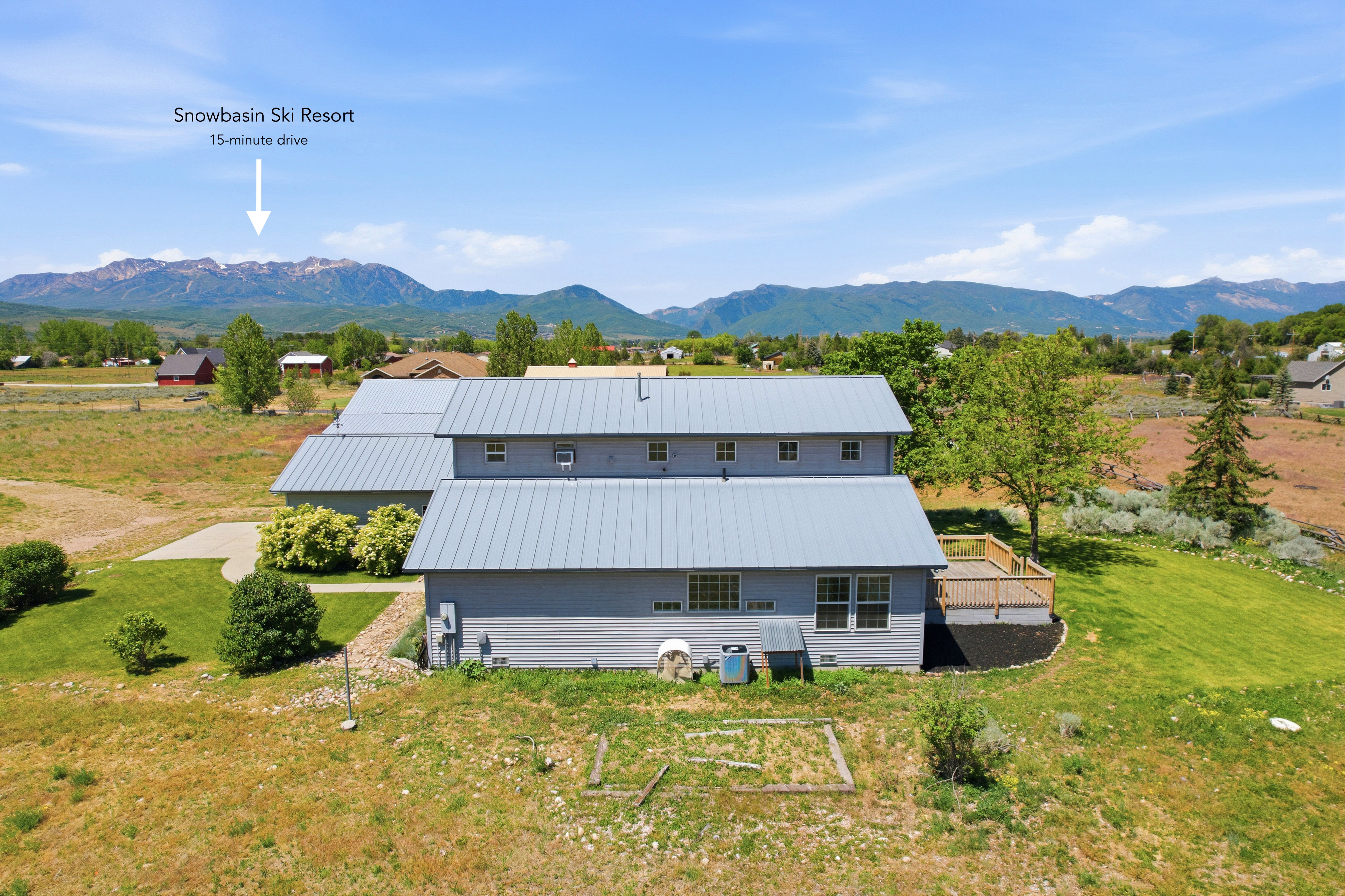 Expansive property featuring a multi-level structure with gray siding and a light gray metal roof