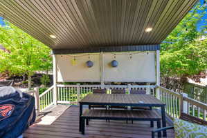Covered outdoor deck with slatted wood-finish flooring