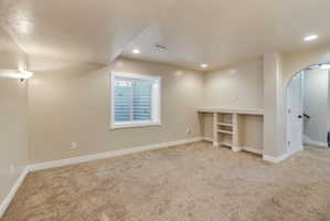 Spacious room with plush carpet flooring, recessed lighting, and a built-in media center