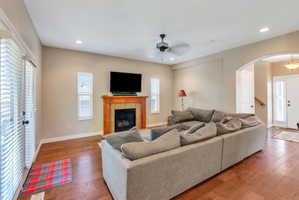 Living space featuring wood-finish flooring and a tiled fireplace with a wood mantle