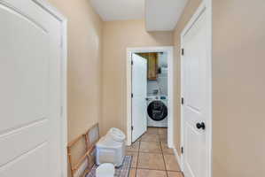Laundry area featuring tile flooring and a front-load washer