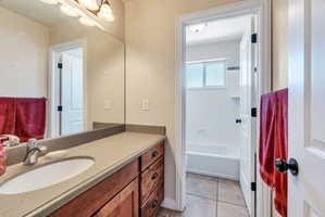 Bathroom vanity featuring a single basin, integrated sink, and wood-finish cabinetry