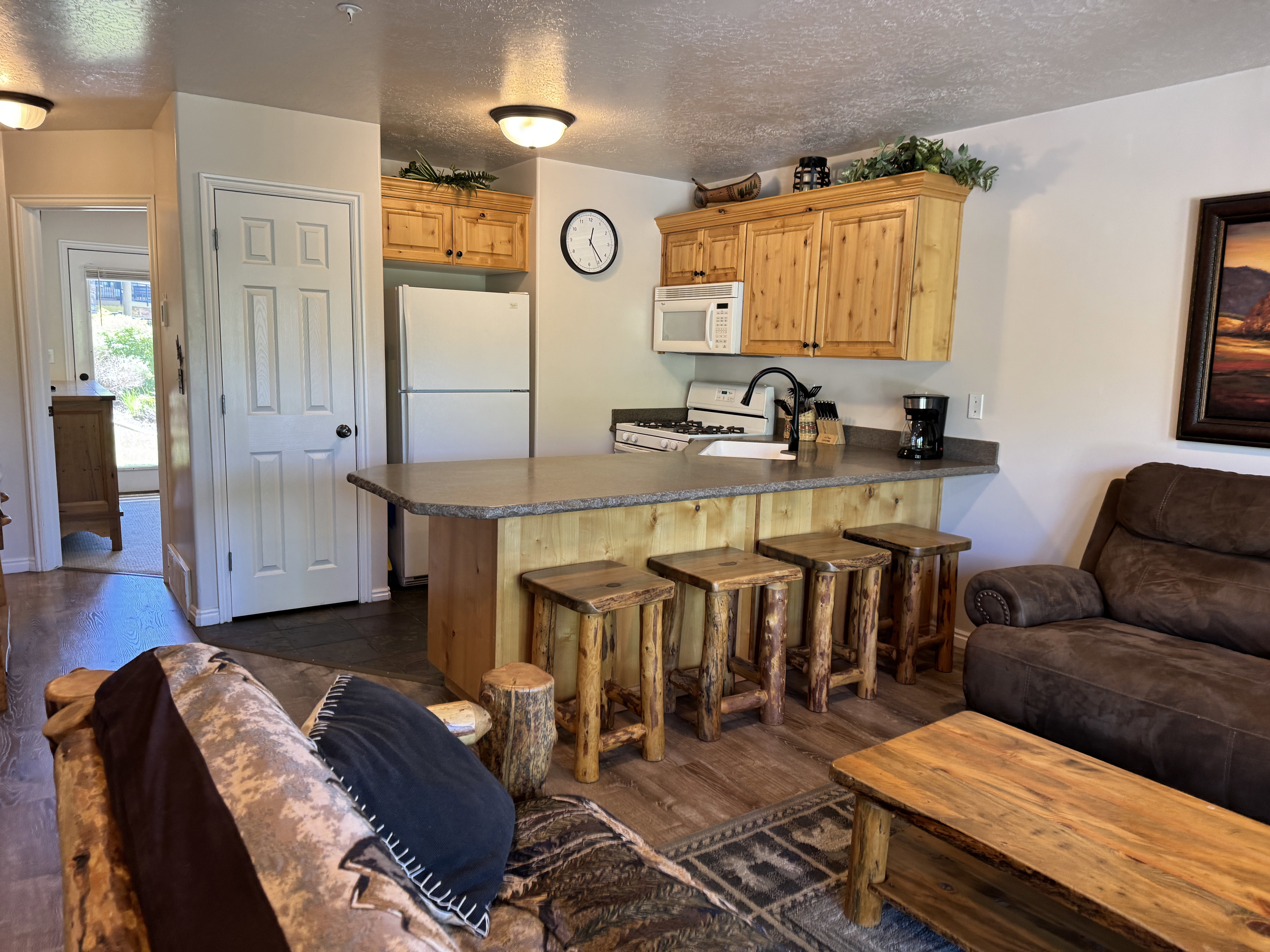 Fully stocked pantry and kitchen with wood-finish cabinetry and bar seating