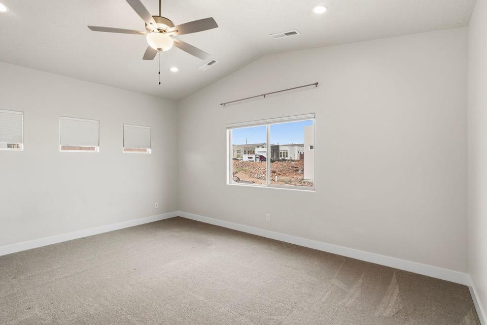 Vaulted ceiling room featuring carpet flooring and a ceiling fan with integrated lighting