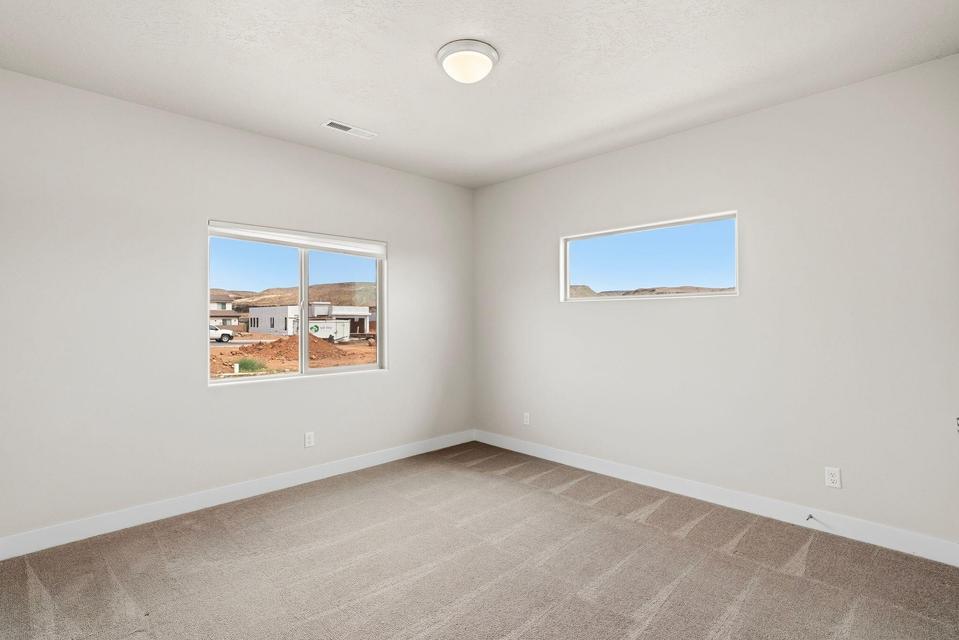 Carpeted room with light-toned walls and white baseboards
