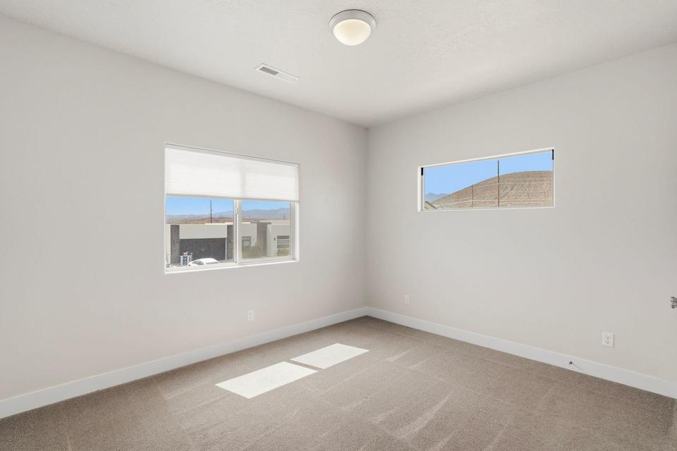 Neutral tone wall paint with white trim, complemented by light brown carpet flooring