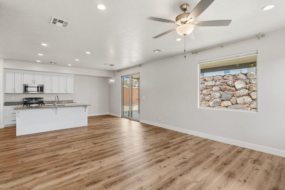 Open-concept living area featuring wood-finish flooring, recessed lighting, and a ceiling fan