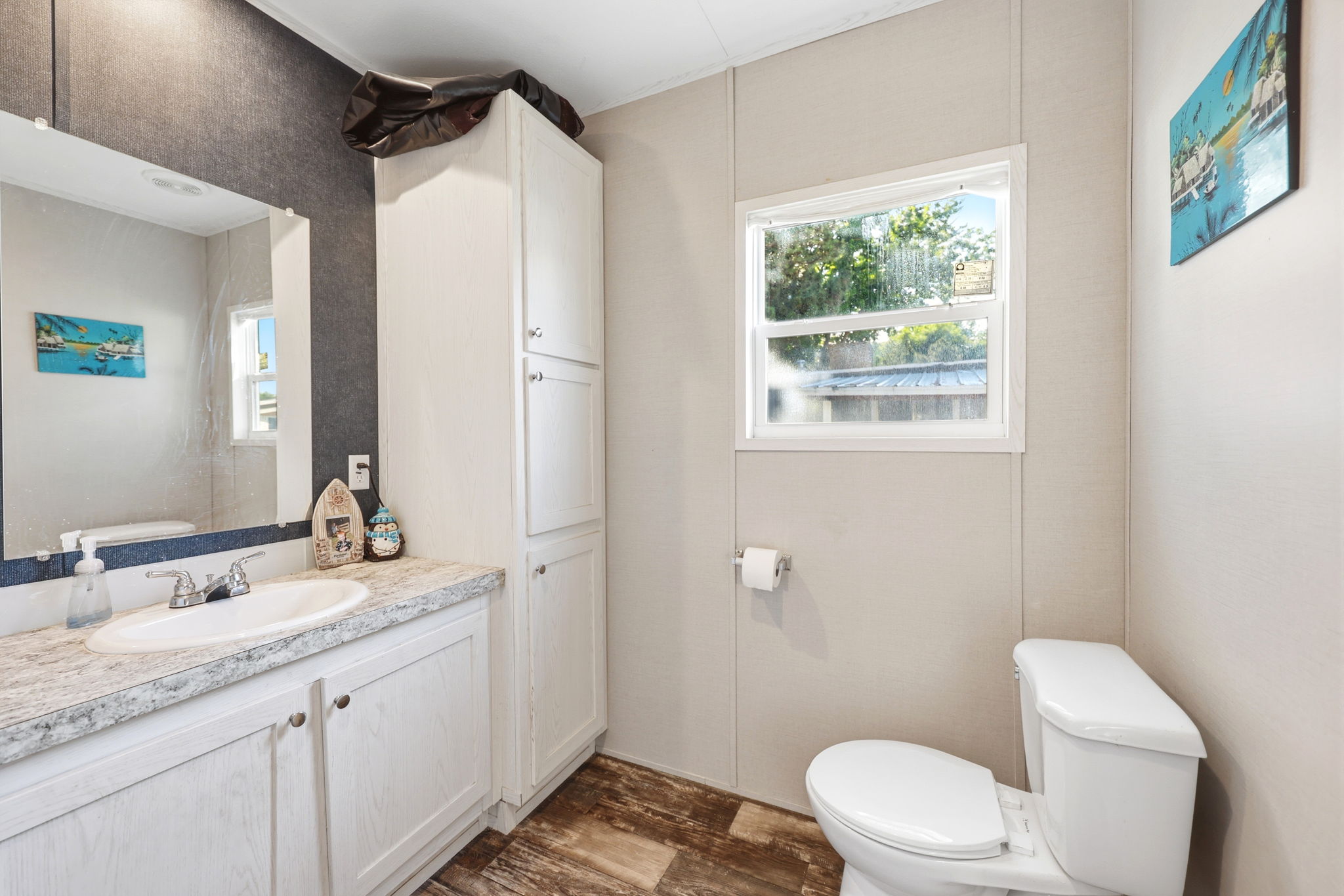 Bathroom vanity featuring an integrated sink, laminate countertop, and white cabinetry