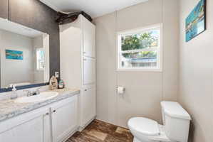 Bathroom vanity featuring an integrated sink, laminate countertop, and white cabinetry