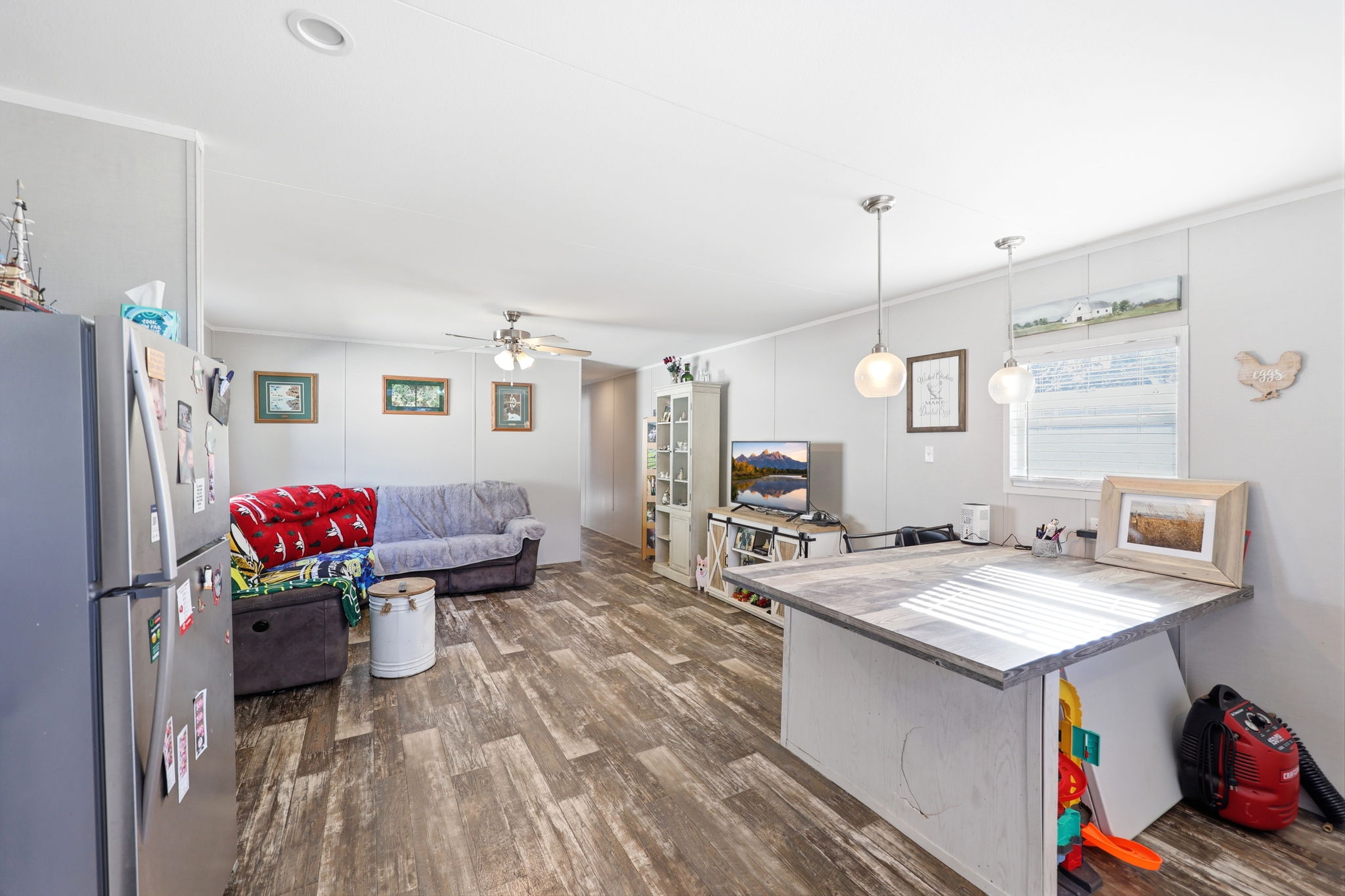 Open-concept living area featuring wood-finish flooring, recessed lighting, and a ceiling fan