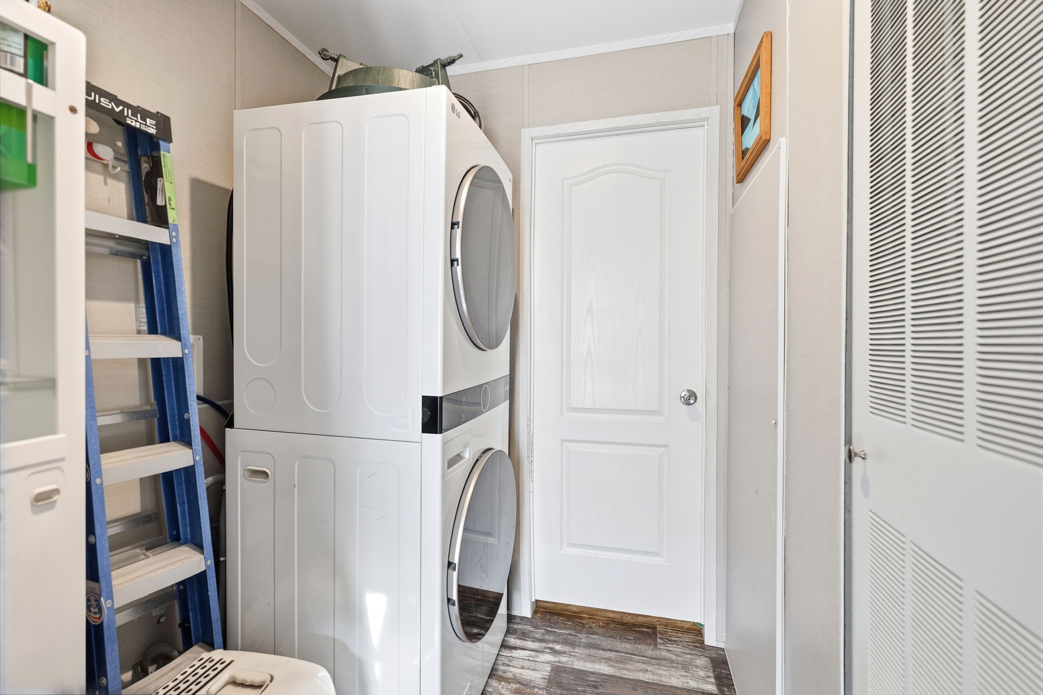 Dedicated laundry area featuring a stacked washer and dryer unit