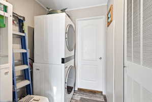 Dedicated laundry area featuring a stacked washer and dryer unit
