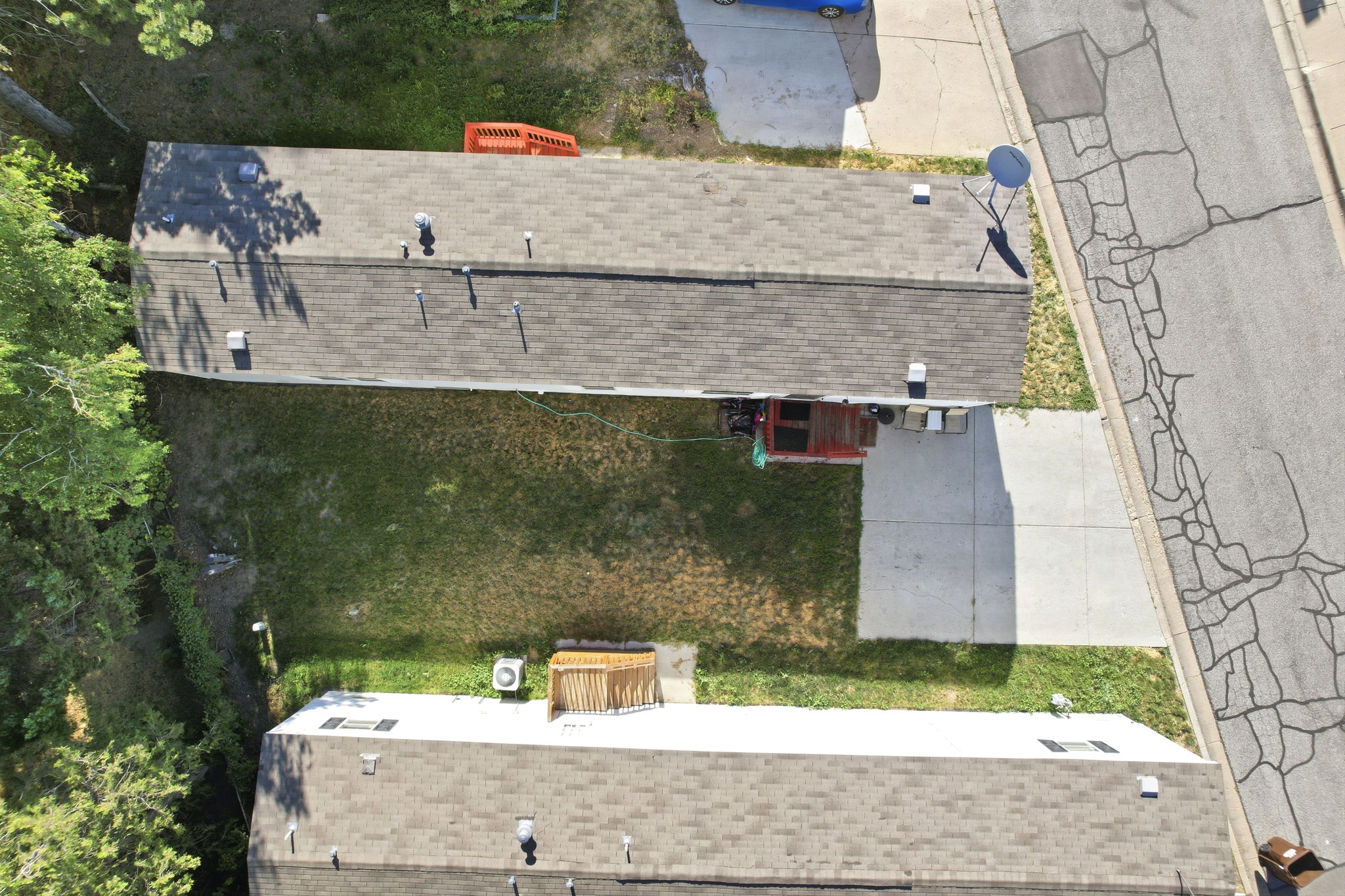 Aerial view showcasing two residential structures with asphalt shingle roofs