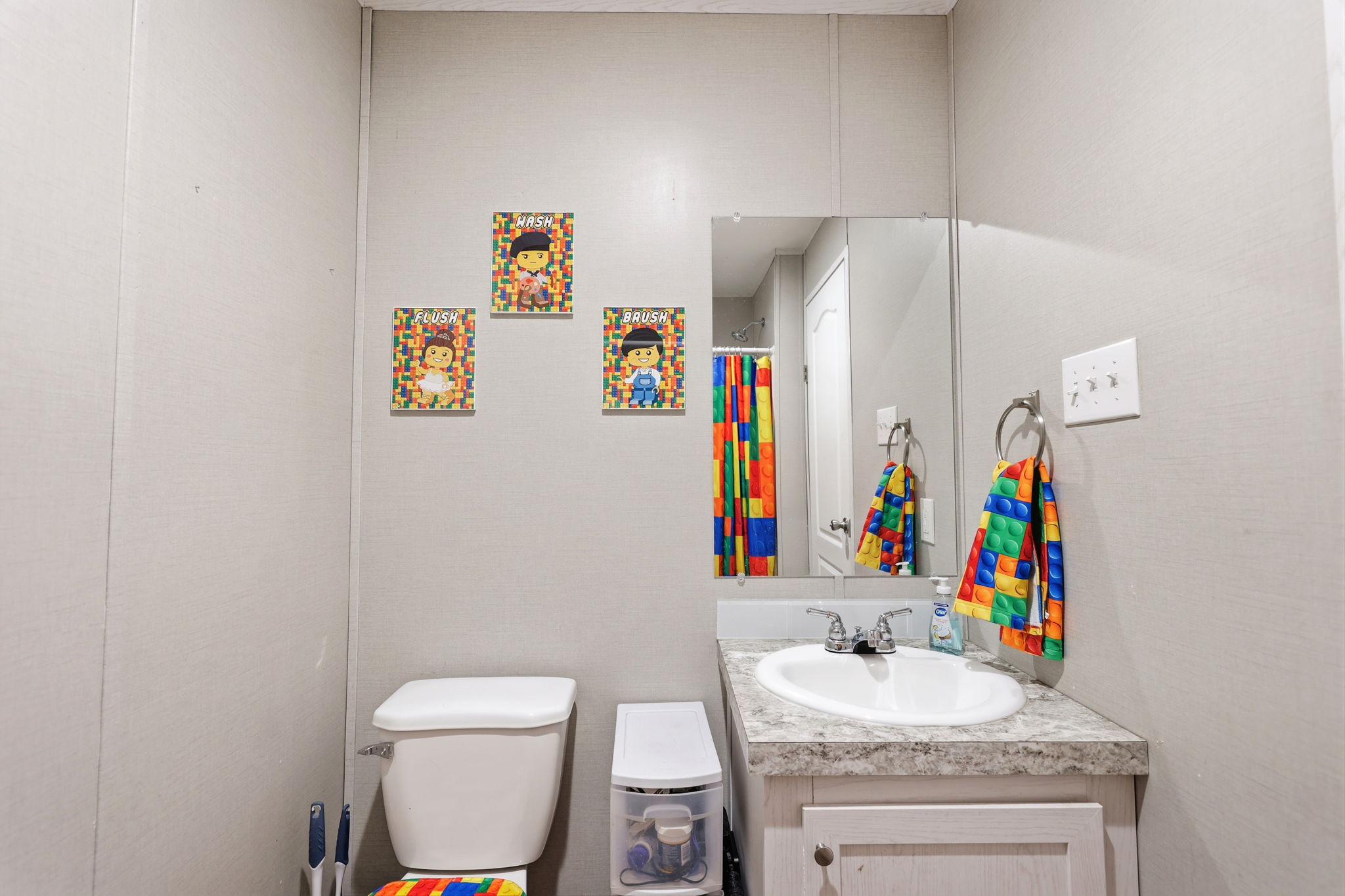 Bathroom featuring a vanity with an oval sink, laminate countertop, and a wall-mounted mirror