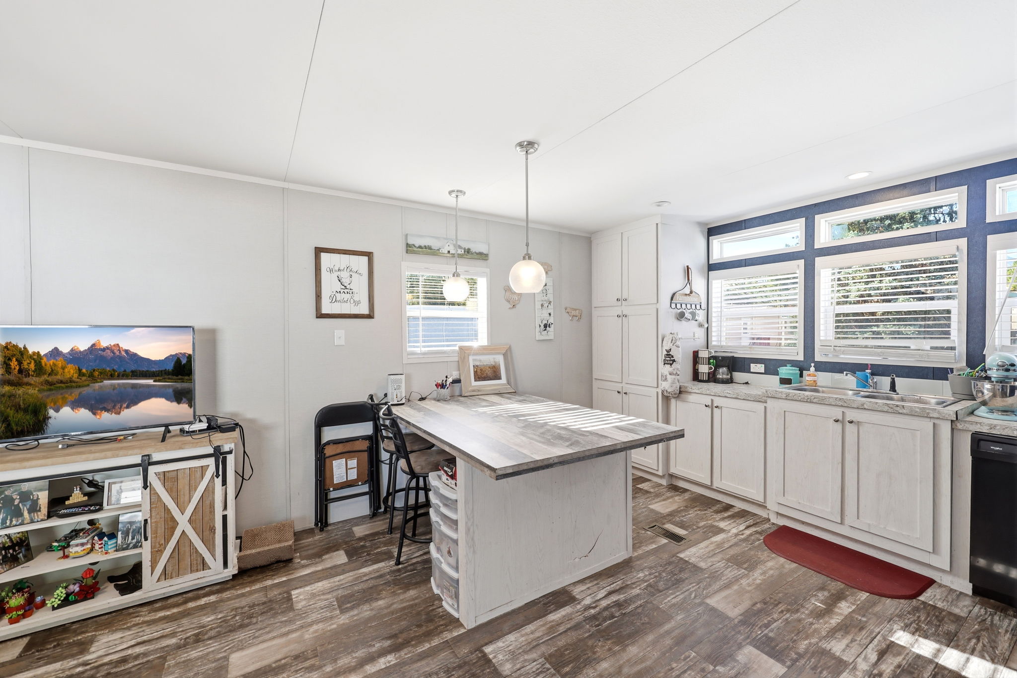 Kitchen area featuring white cabinetry, light countertops, and a wood-finish island with seating
