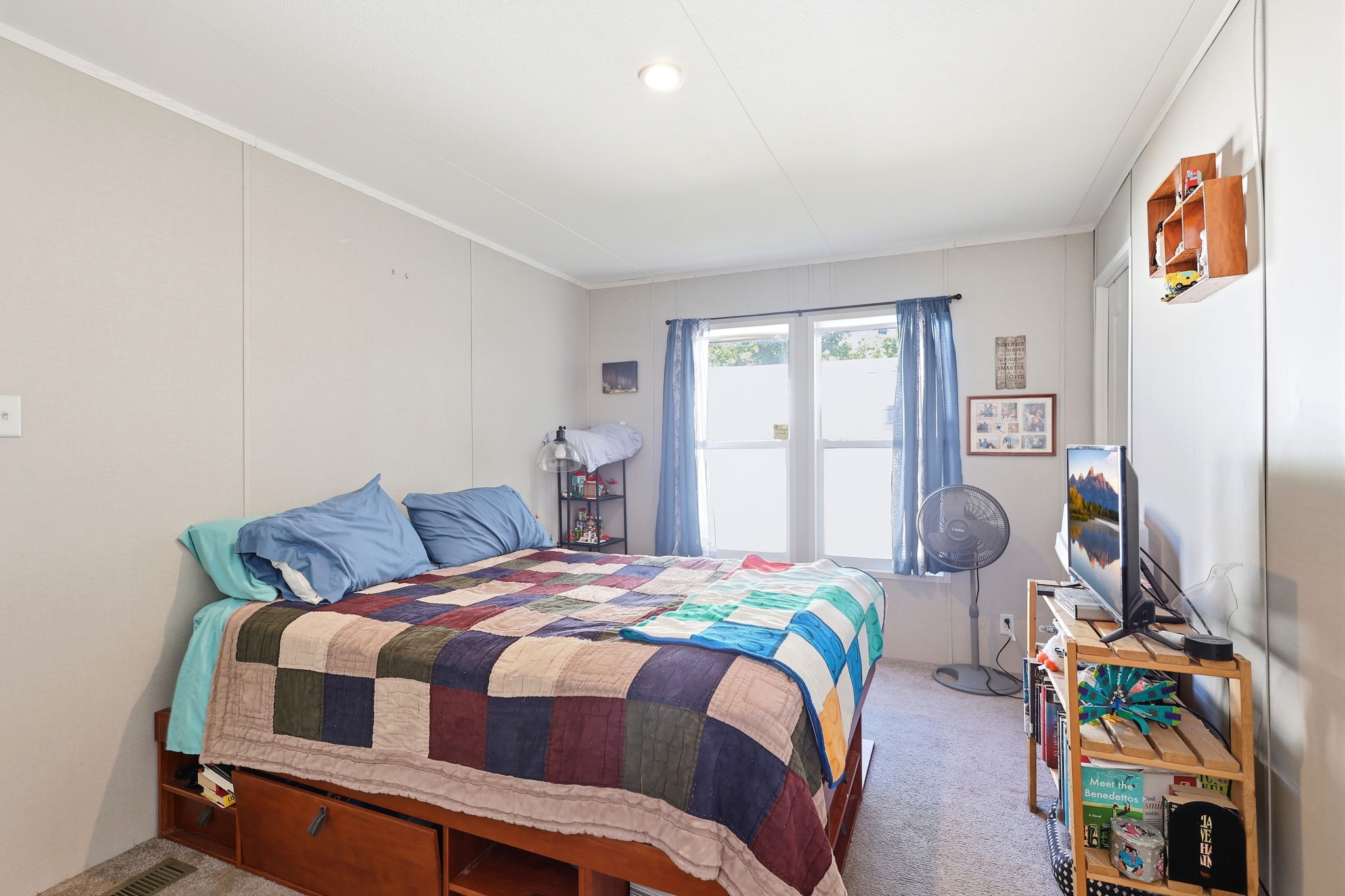 Bedroom featuring paneled walls, a carpeted floor, and a double window with blinds