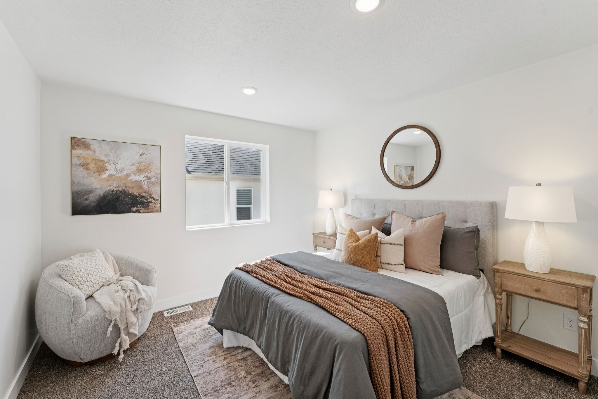 Bedroom featuring a light gray upholstered headboard, recessed lighting, and a white framed window