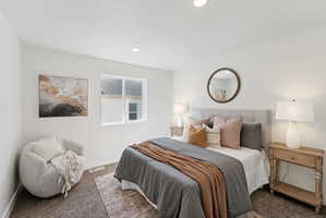 Bedroom featuring a light gray upholstered headboard, recessed lighting, and a white framed window