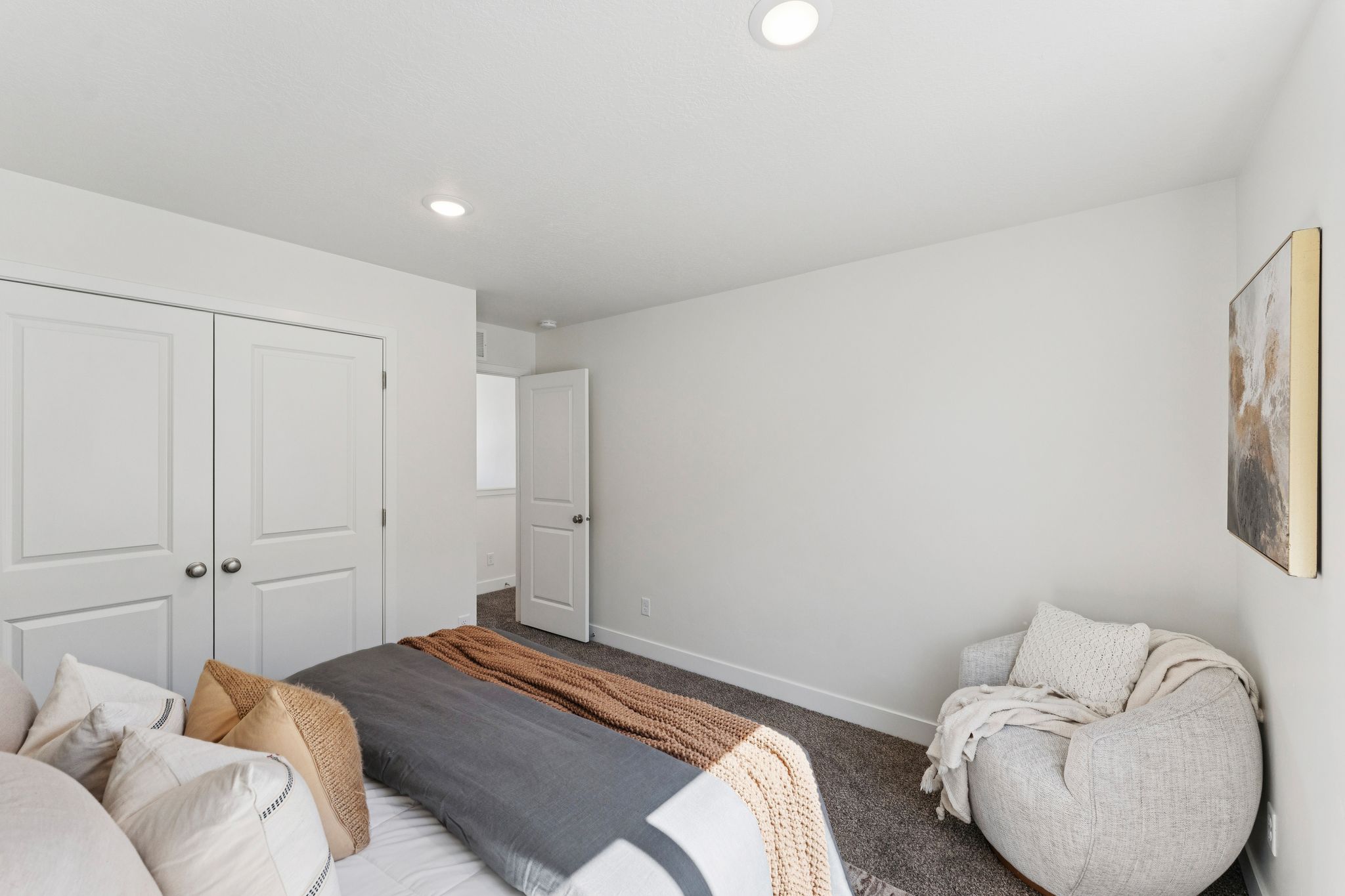 Carpeted bedroom with recessed lighting and white bi-fold closet doors