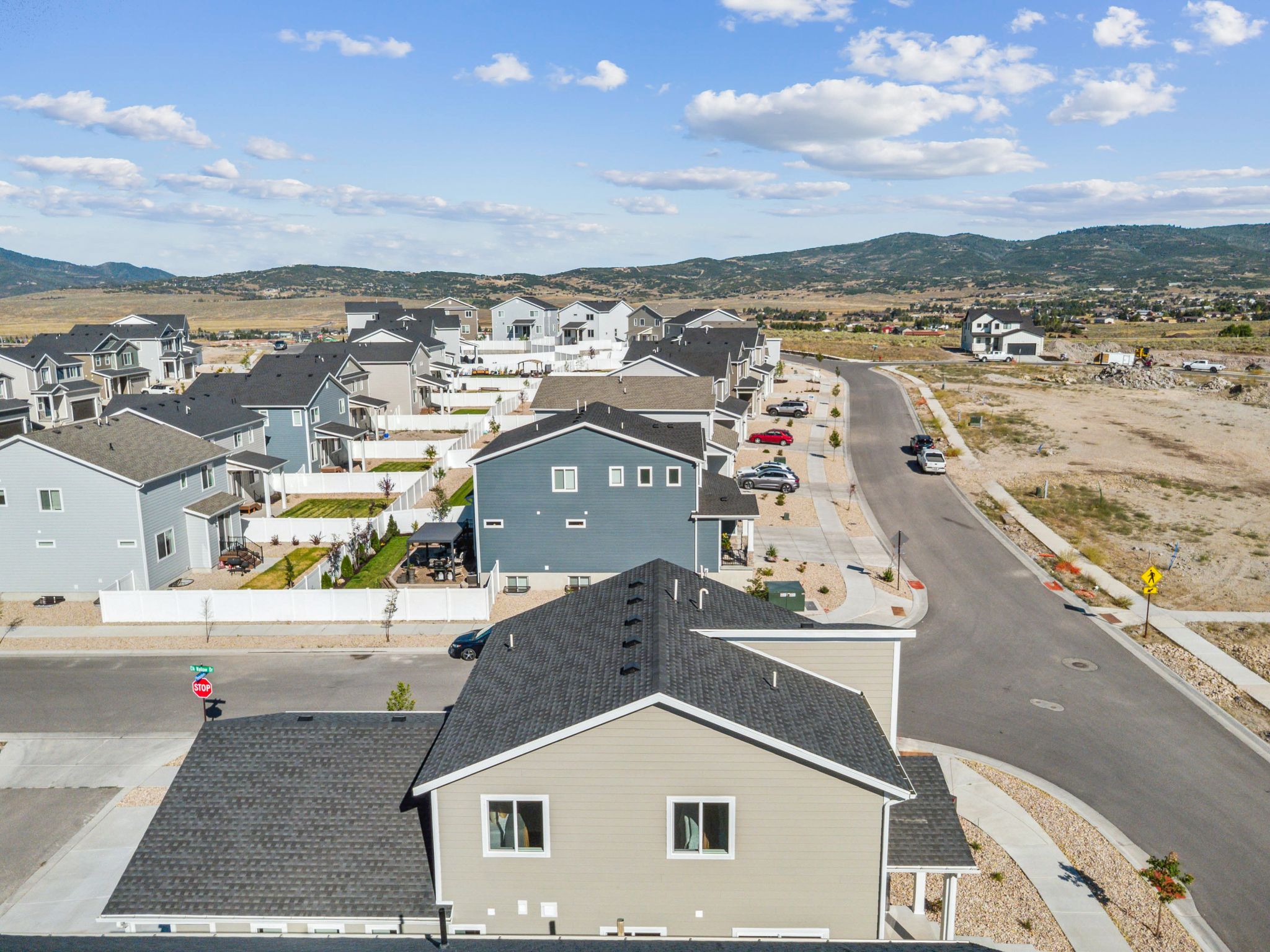 Aerial perspective showcasing a residential community with a variety of single-family homes, established street infrastructure, and mountain topography in the background
