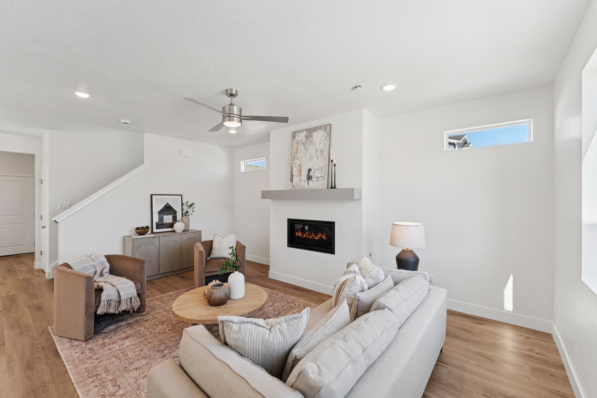 Bright living area featuring wood-finish flooring, recessed lighting, and a contemporary ceiling fan