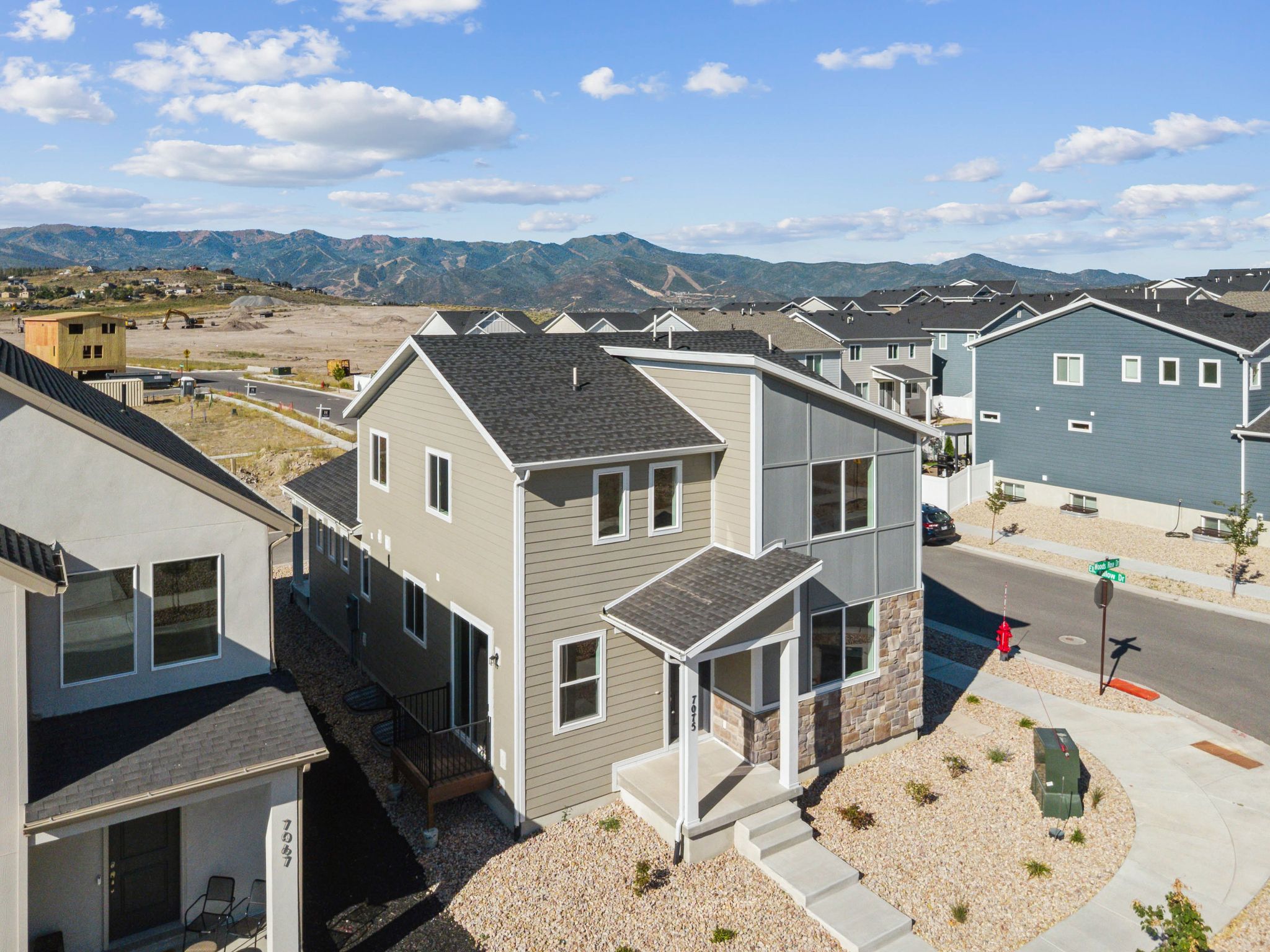 Modern two-story residence featuring a mixed-material facade with horizontal siding and stone accents