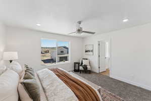 Bedroom featuring a large picture window, recessed lighting, and a ceiling fan with light