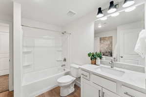 Modern bathroom featuring a white vanity with an integrated sink, a large mirror, and contemporary overhead lighting